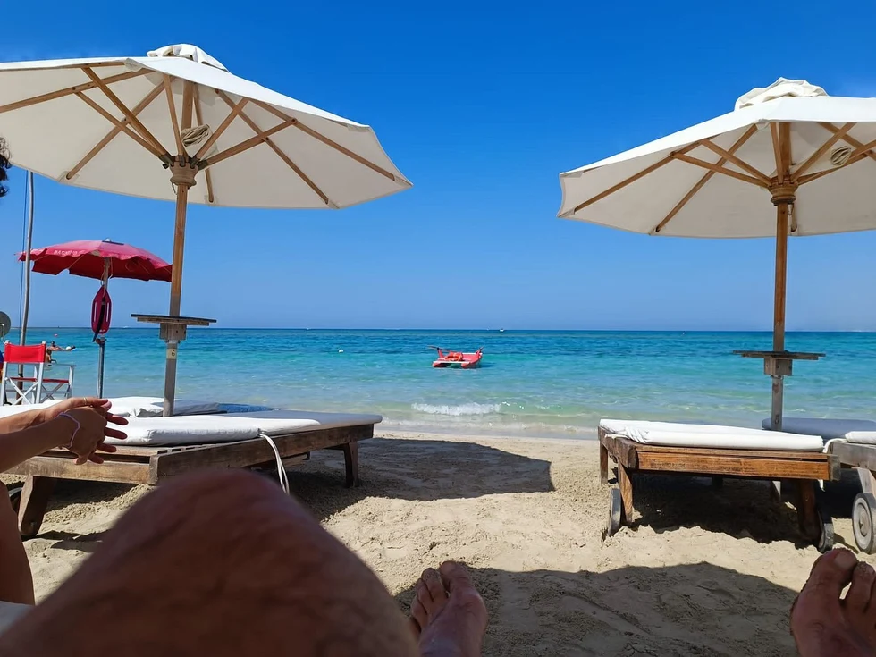 Turquoise zeewater en parasols aan het strand van Puglia